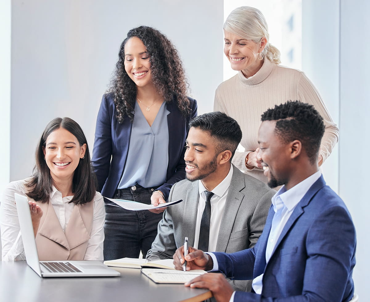 Group of people having a meeting, looking at a laptop